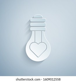 Paper cut Heart shape in a light bulb icon isolated on grey background. Love symbol. Valentine day symbol. Paper art style. Vector Illustration