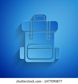 Paper cut Hiking backpack icon isolated on blue background. Camping and mountain exploring backpack. Paper art style. Vector Illustration