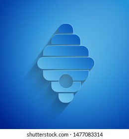 Paper cut Hive for bees icon isolated on blue background. Beehive symbol. Apiary and beekeeping. Sweet natural food. Paper art style. Vector Illustration