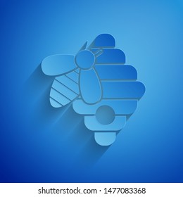 Paper cut Hive for bees icon isolated on blue background. Beehive symbol. Apiary and beekeeping. Sweet natural food. Paper art style. Vector Illustration
