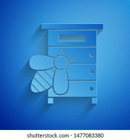 Paper cut Hive for bees icon isolated on blue background. Beehive symbol. Apiary and beekeeping. Sweet natural food. Paper art style. Vector Illustration