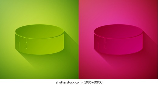 Paper cut Hockey puck icon isolated on green and pink background. Sport equipment. Paper art style. Vector Illustration