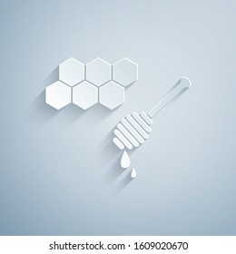 Paper cut Honeycomb with honey dipper stickicon isolated on grey background. Honey ladle. Honey cells symbol. Sweet natural food. Paper art style. Vector Illustration