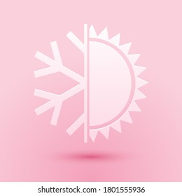 Cortado de papel Símbolo caliente y frío. Icono de sol y copo de nieve aislado en fondo rosado. Símbolo de invierno y verano. Estilo de arte de papel. Vector.