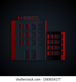 Paper cut Hotel building icon isolated on black background. Paper art style. Vector Illustration