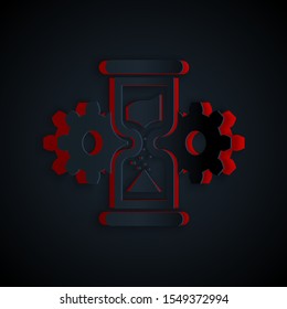 Paper cut Hourglass and gear icon isolated on black background. Time Management symbol. Clock and gear icon. Business concept. Paper art style. Vector Illustration