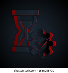 Paper cut Hourglass and gear icon isolated on black background. Time Management symbol. Clock and gear icon. Productivity symbol. Paper art style. Vector Illustration