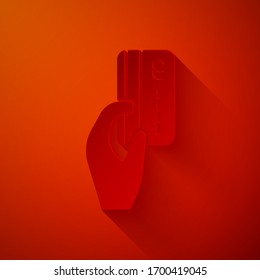 Cortado de papel Mano humana con icono de tarjeta de crédito aislado en rojo fondo. Pago en línea. Pagar con tarjeta. Operaciones financieras. Estilo de arte de papel. Ilustración vectorial