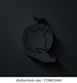 El papel cortó las manos humanas sujetando el icono del globo terrestre aislado en el fondo negro. Salvar el concepto de tierra. Estilo de arte de papel. Ilustración vectorial