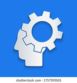 Paper cut Human head with gear inside icon isolated on blue background. Artificial intelligence. Thinking brain. Symbol work of brain. Paper art style. Vector Illustration