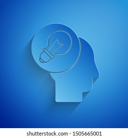 Paper cut Human head with lamp bulb icon isolated on blue background. Paper art style. Vector Illustration