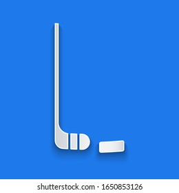 Paper cut Ice hockey stick and puck icon isolated on blue background. Paper art style. Vector Illustration