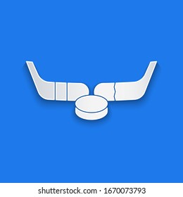 Paper cut Ice hockey sticks and puck icon isolated on blue background. Game start. Paper art style. Vector Illustration