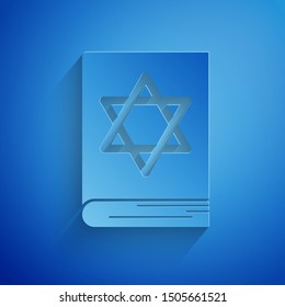 Paper cut Jewish torah book icon isolated on blue background. Pentateuch of Moses. On the cover of the Bible is the image of the Star of David. Paper art style. Vector Illustration