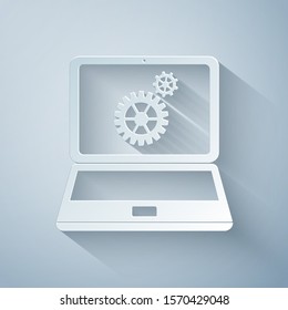 Paper cut Laptop and gears icon isolated on grey background. Laptop service concept. Paper art style. Vector Illustration
