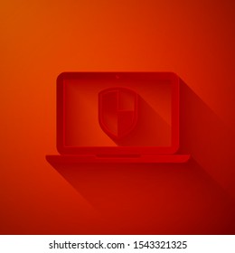 Paper cut Laptop protected with shield icon isolated on red background. Internet security. PC security, firewall technology, privacy safety. Paper art style. Vector Illustration