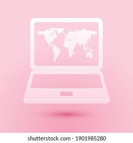 Paper cut Laptop with world map on screen icon isolated on pink background. World map geography symbol. Paper art style. Vector.