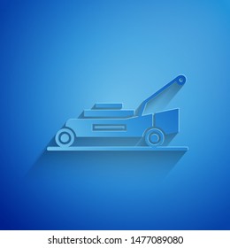 Paper cut Lawn mower icon isolated on blue background. Lawn mower cutting grass. Paper art style. Vector Illustration