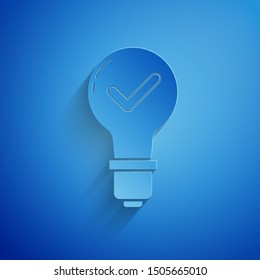 Paper cut Light bulb and check mark icon isolated on blue background. Concept of idea. Paper art style. Vector Illustration