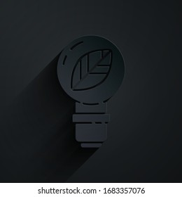 Bombilla de papel con icono de hoja aislada en fondo negro. Concepto de energía ecológica. Concepto de energía alternativa. Estilo de arte de papel. Ilustración vectorial