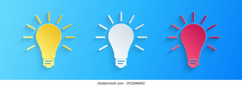 Cortado de papel Bombilla de luz con un icono de brillo de rayos aislado en el fondo azul. Símbolo de energía e ideas. Luz eléctrica. Estilo de arte de papel. Vector.