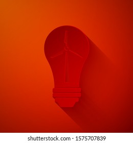 Paper cut Light bulb with wind turbine as idea of eco friendly source of energy icon isolated on red background. Alternative energy concept. Paper art style. Vector Illustration