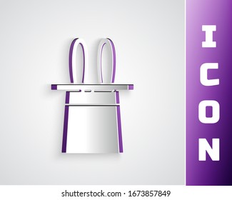 Paper cut Magician hat and rabbit ears icon isolated on grey background. Magic trick. Mystery entertainment concept. Paper art style. Vector Illustration