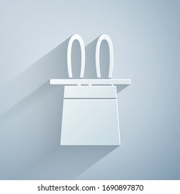 Paper cut Magician hat and rabbit ears icon isolated on grey background. Magic trick. Mystery entertainment concept. Paper art style. Vector Illustration