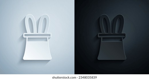 Paper cut Magician hat and rabbit ears icon isolated on grey and black background. Magic trick. Mystery entertainment concept. Paper art style. Vector