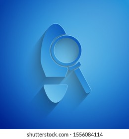 Paper cut Magnifying glass with footsteps icon isolated on blue background. Detective is investigating. To follow in the footsteps. Paper art style. Vector Illustration