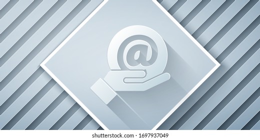 Paper cut Mail and e-mail in hand icon isolated on grey background. Envelope symbol e-mail. Email message sign. Paper art style. Vector Illustration