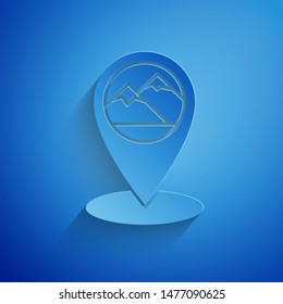Paper cut Map pointer with mountain icon isolated on blue background. Mountains travel icon. Paper art style. Vector Illustration
