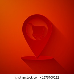 Paper cut Map pointer with shopping cart icon isolated on red background. Pin point shop and shopping. Supermarket basket symbol. Paper art style. Vector Illustration