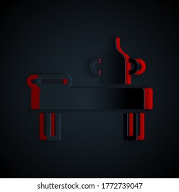 Paper cut Massage table with oil icon isolated on black background. Paper art style. Vector