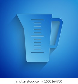 Paper cut Measuring cup to measure dry and liquid food icon isolated on blue background. Plastic graduated beaker with handle. Paper art style. Vector Illustration