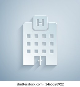 Paper cut Medical hospital building with cross icon isolated on grey background. Medical center. Health care. Paper art style. Vector Illustration