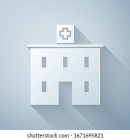 Paper cut Medical hospital building with cross icon isolated on grey background. Medical center. Health care. Paper art style. Vector Illustration