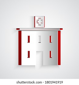 Paper cut Medical hospital building with cross icon isolated on grey background. Medical center. Health care. Paper art style. Vector Illustration