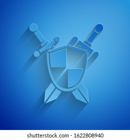 Paper cut Medieval shield with crossed swords icon isolated on blue background. Paper art style. Vector Illustration