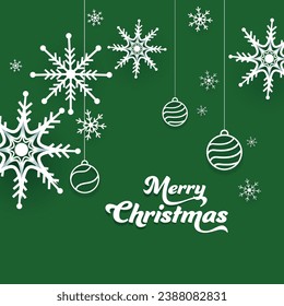 Paper Cut Merry Christmas Text with Hanging Baubles and Snowflakes Decorated on Green Background.