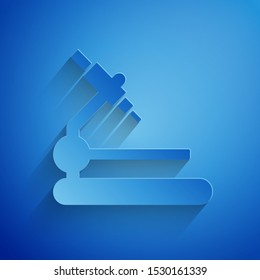 Paper cut Microscope icon isolated on blue background. Chemistry, pharmaceutical instrument, microbiology magnifying tool. Paper art style. Vector Illustration