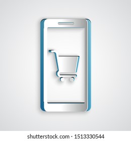 Paper cut Mobile phone and shopping cart icon isolated on grey background. Online buying symbol. Supermarket basket symbol. Paper art style. Vector Illustration