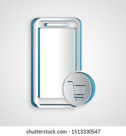 Paper cut Mobile phone and shopping cart icon isolated on grey background. Online buying symbol. Supermarket basket symbol. Paper art style. Vector Illustration