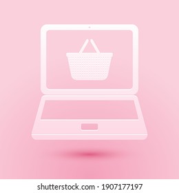 Paper cut Mobile phone and shopping basket icon isolated on pink background. Online buying symbol. Supermarket basket symbol. Paper art style. Vector.