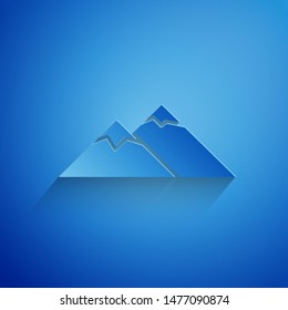 Paper cut Mountains icon isolated on blue background. Symbol of victory or success concept. Paper art style. Vector Illustration