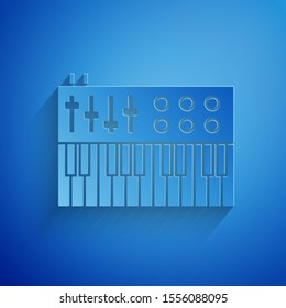 Paper cut Music synthesizer icon isolated on blue background. Electronic piano. Paper art style. Vector Illustration