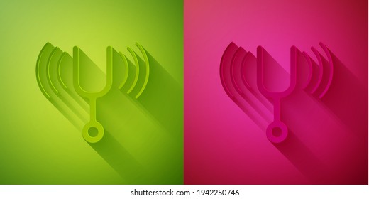 Paper cut Musical tuning fork for tuning musical instruments icon isolated on green and pink background. Paper art style. Vector