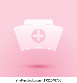 Paper cut Nurse hat with cross icon isolated on pink background. Medical nurse cap sign. Paper art style. Vector.