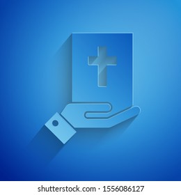 Paper cut Oath on the Holy Bible icon isolated on blue background. The procedure in court. Truth and truth. Promise before god. Paper art style. Vector Illustration