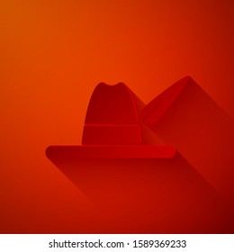 Paper cut Oktoberfest hat icon isolated on red background. Hunter hat with feather. German hat. Paper art style. Vector Illustration